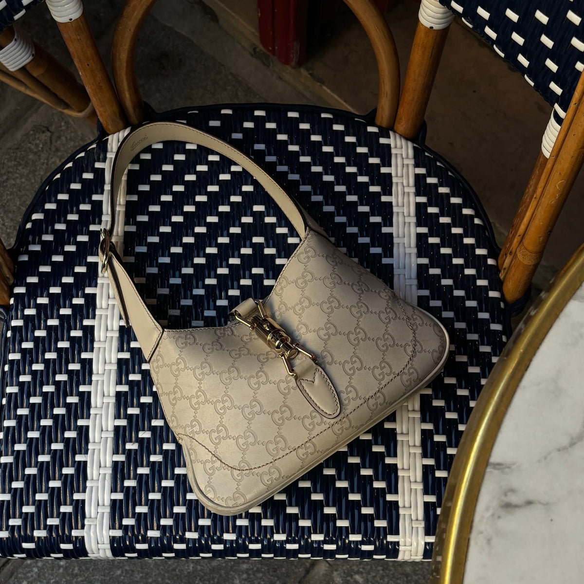 Beige vintage handbag on a woven bistro chair