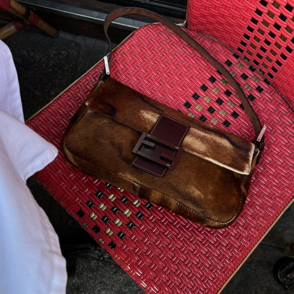 Brown vintage handbag on a red woven chair