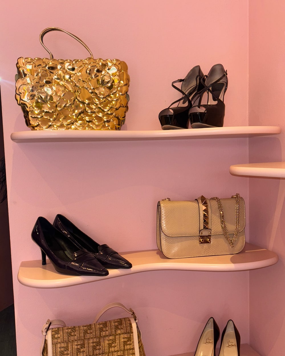 Vintage bags and shoes on pink shelves at the Gizeye Milan boutique