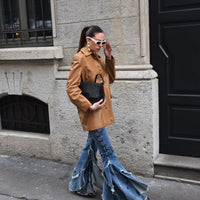 Vintage outfit with a tan jacket, jeans and black handbag
