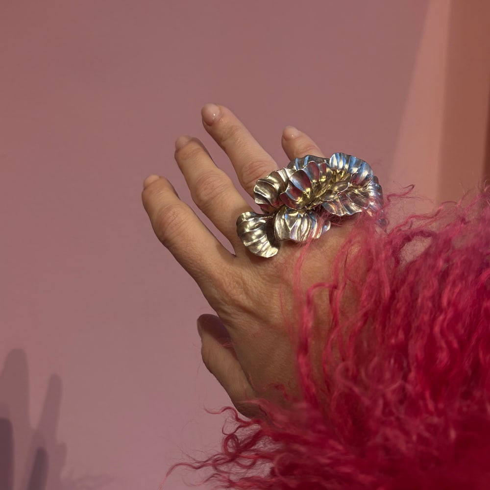 Statement jewellery styled with a pink feathered sleeve