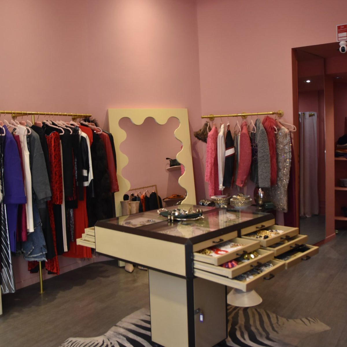 Interior of the Gizeye Milan boutique with pink walls, clothing and jewellery displays