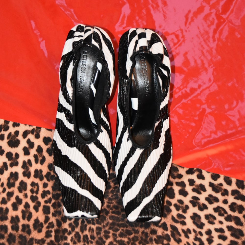 Zebra-print vintage shoes against red and animal-print surfaces