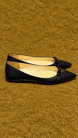 Prada ballet flats — side view on muted gold background