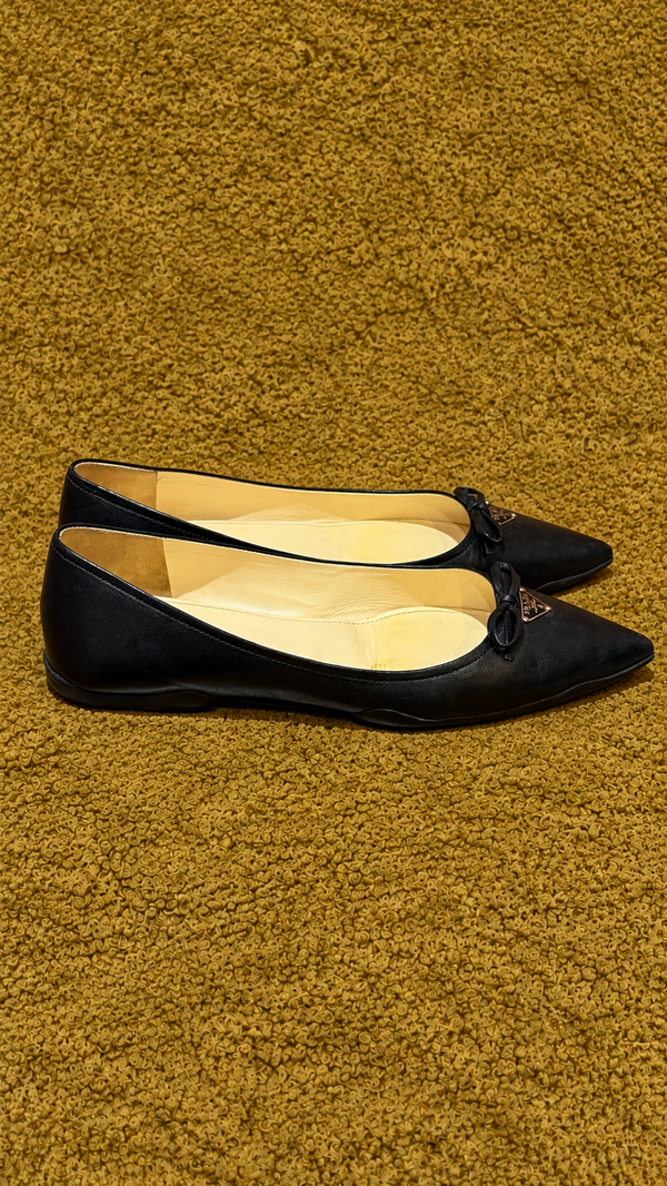 Prada ballet flats — side view on muted gold background